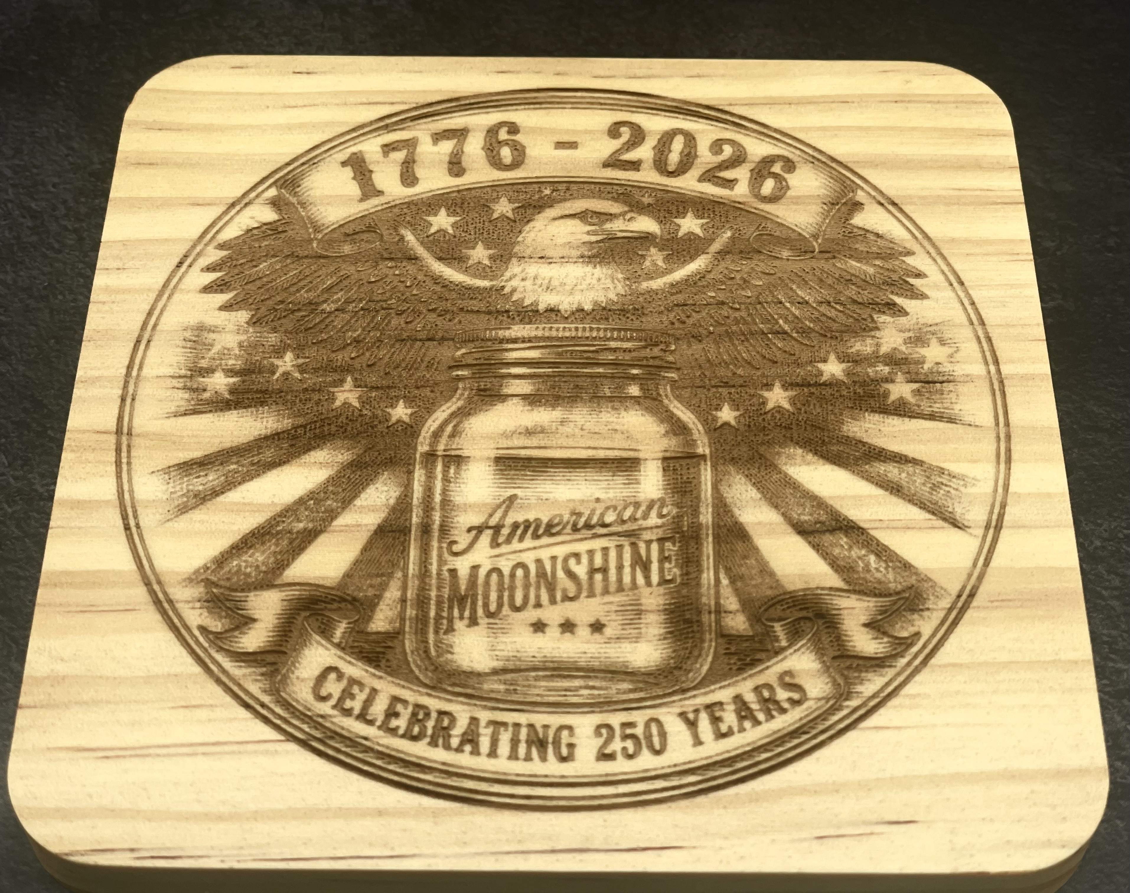 American Moonshine wood coaster with a 1776 to 2026 eagle design, laser engraved by BurnlineLab
